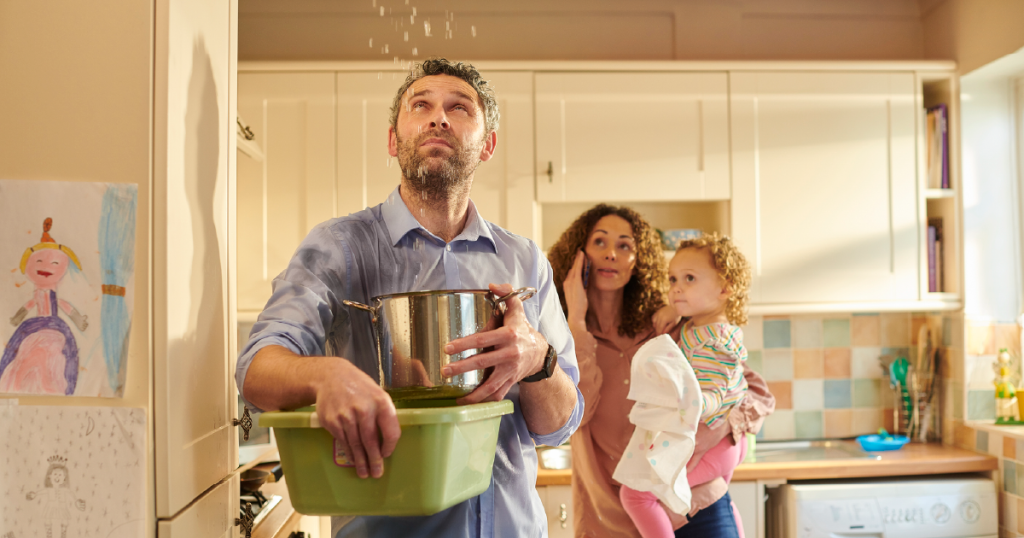 Dad holding pots catching water from leaky roof
